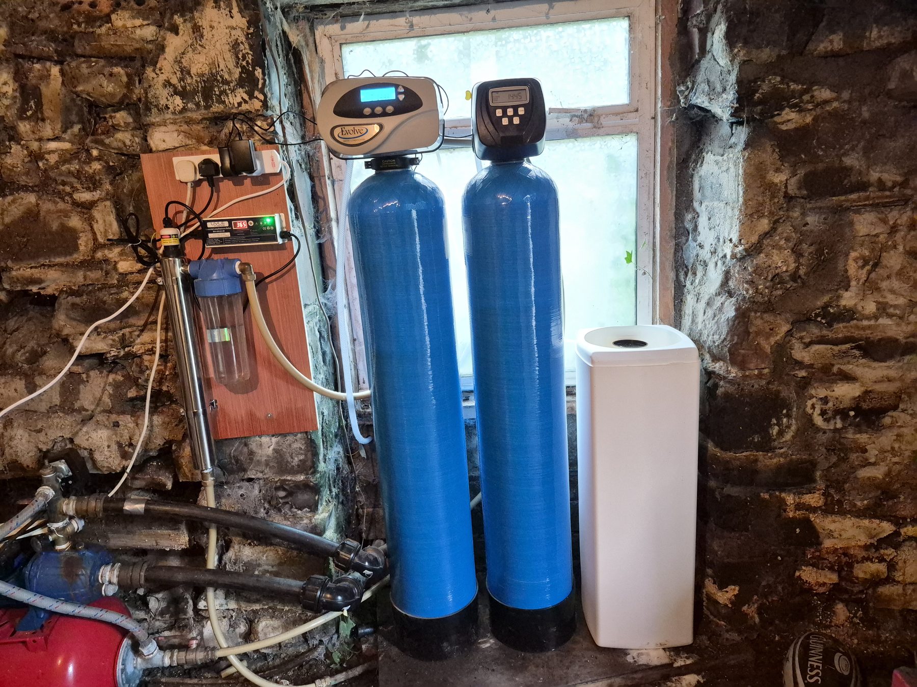 Twin-tank water treatment system installed against a wall